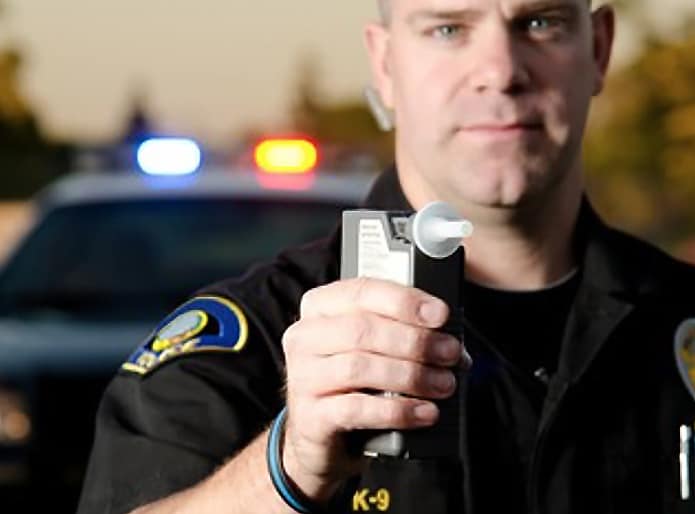 Policeman holding a Breathalyzer.